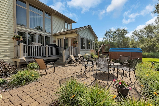 view of patio / terrace featuring outdoor dining area, a jacuzzi, and a wooden deck