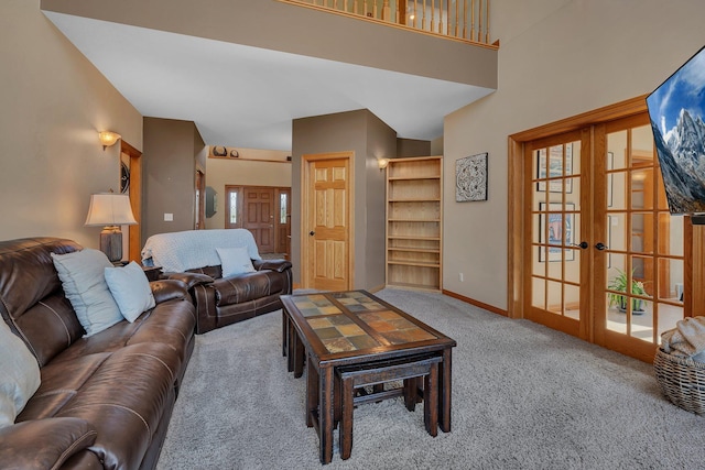 carpeted living area featuring baseboards and french doors