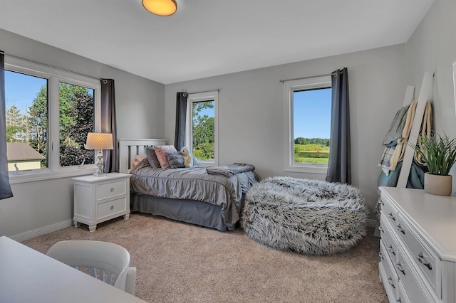 bedroom featuring baseboards and light colored carpet