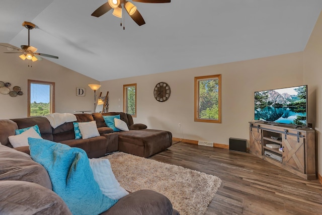 living area featuring vaulted ceiling, dark wood-type flooring, visible vents, and a ceiling fan