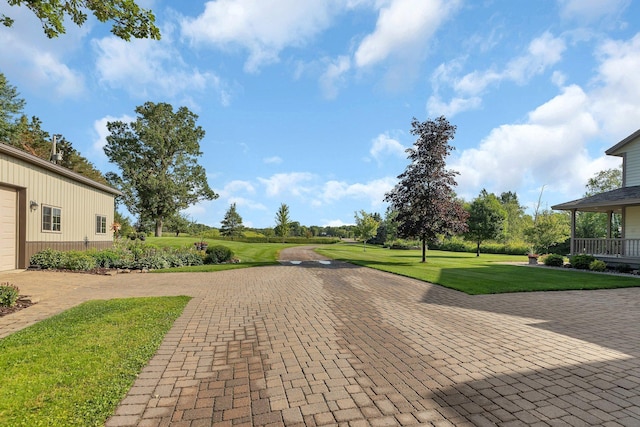 view of home's community with a yard and decorative driveway