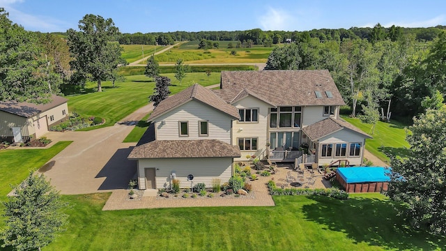 rear view of property with a sunroom, a shingled roof, aphalt driveway, and a wooden deck