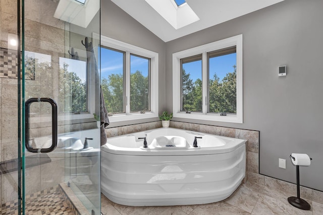 full bath with vaulted ceiling with skylight, a tile shower, and a bath