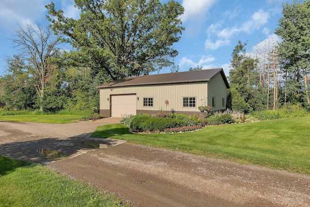 view of home's exterior with metal roof, dirt driveway, an outbuilding, and a yard