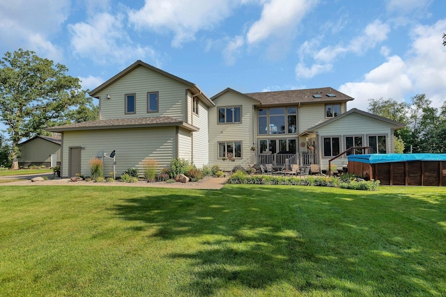 rear view of property featuring a deck and a yard