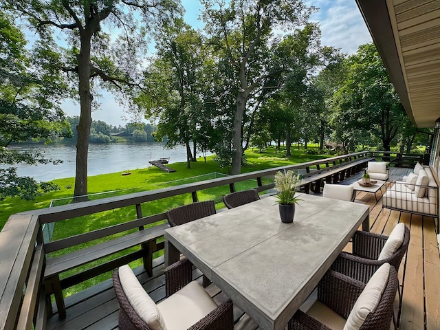 wooden deck with a water view and a lawn