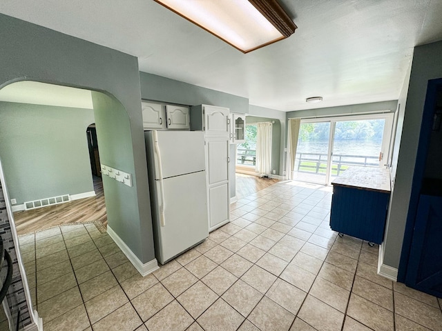 kitchen featuring light wood-type flooring, white cabinetry, and white refrigerator