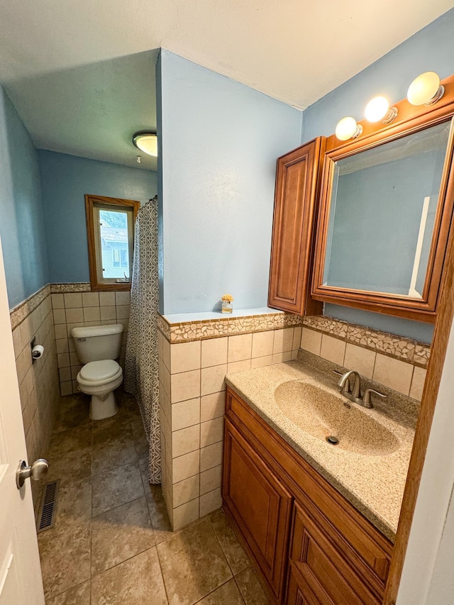 bathroom featuring tile walls, vanity, and toilet