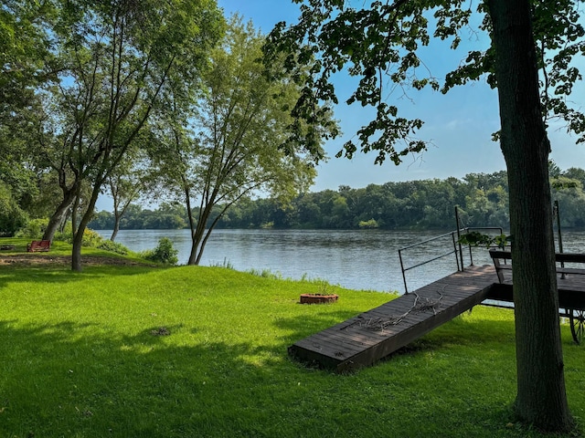 surrounding community featuring a dock, a water view, and a yard