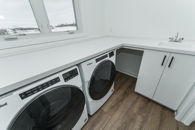 clothes washing area featuring sink, dark wood-type flooring, and washer and clothes dryer