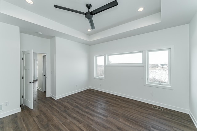 interior space featuring ceiling fan, dark hardwood / wood-style flooring, and a tray ceiling