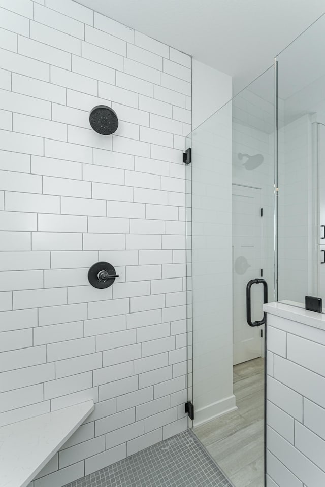 bathroom featuring hardwood / wood-style floors and a shower with door