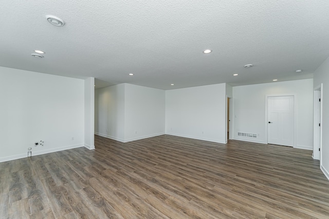 spare room featuring hardwood / wood-style floors and a textured ceiling