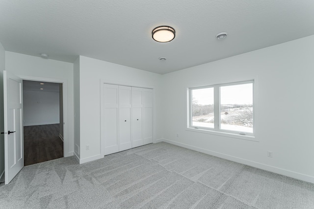 unfurnished bedroom featuring light carpet and a closet