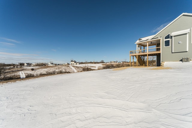 yard covered in snow with cooling unit and a balcony