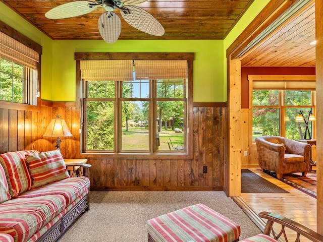 sunroom featuring wooden ceiling, a healthy amount of sunlight, and ceiling fan