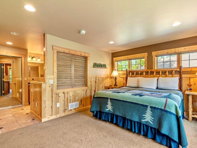 bedroom with carpet and wood walls