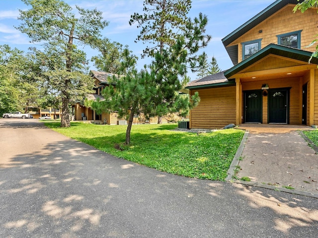 view of front of home with central AC and a front yard
