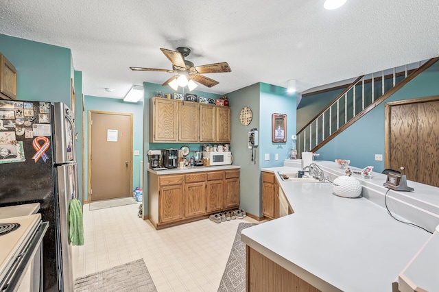 kitchen featuring kitchen peninsula, ceiling fan, light tile patterned floors, and sink