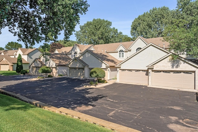 view of front of house featuring driveway, a residential view, and brick siding