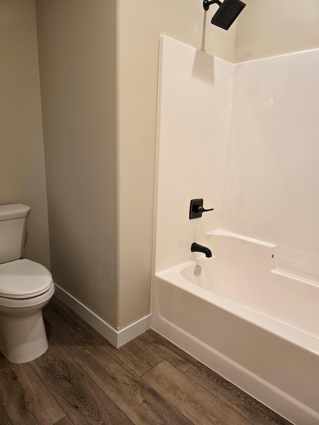 bathroom featuring shower / bathtub combination, toilet, and wood-type flooring