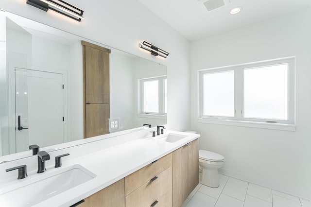 bathroom with tile patterned floors, double sink vanity, and toilet