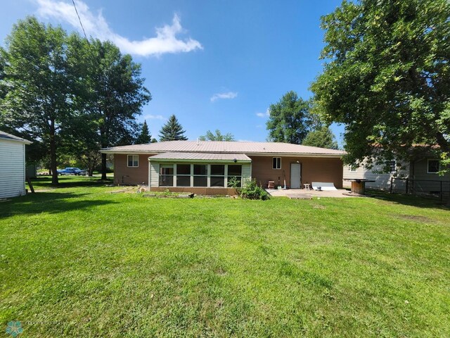 back of property featuring a patio and a lawn