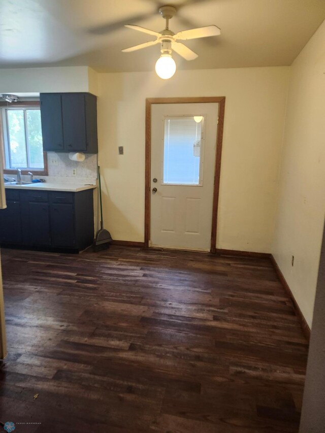 interior space featuring ceiling fan, sink, and dark wood-type flooring