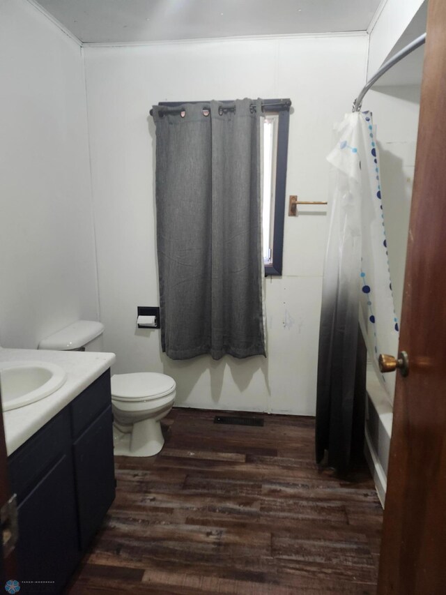 full bathroom featuring toilet, vanity, hardwood / wood-style flooring, and shower / tub combo