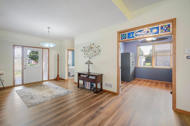 entrance foyer featuring visible vents, plenty of natural light, and wood finished floors