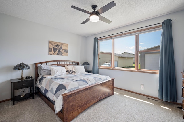 bedroom featuring a textured ceiling, carpet, visible vents, and baseboards