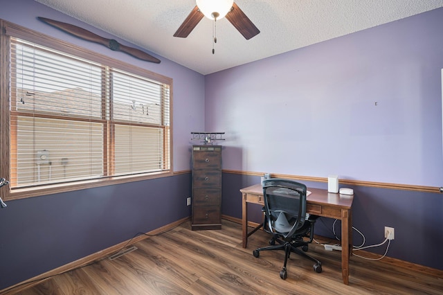 office space featuring a textured ceiling, a ceiling fan, baseboards, and wood finished floors