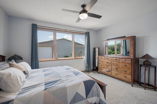 carpeted bedroom with a textured ceiling and a ceiling fan