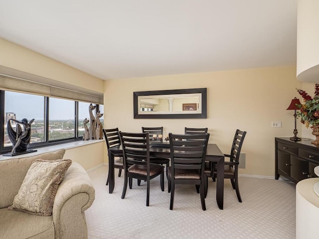 dining room with light colored carpet and baseboards