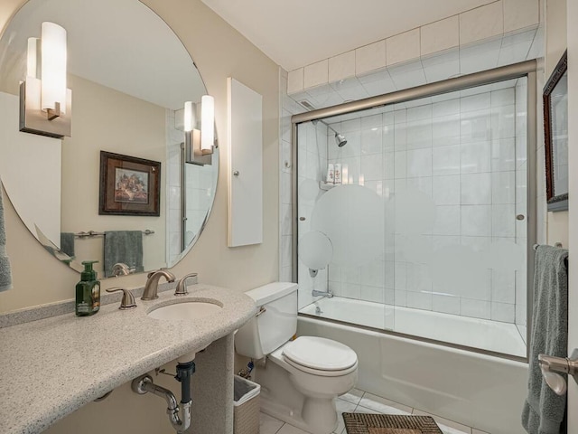 bathroom featuring toilet, enclosed tub / shower combo, a sink, and tile patterned floors