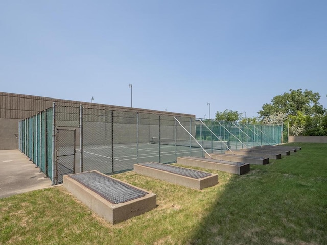 view of sport court with fence and a yard