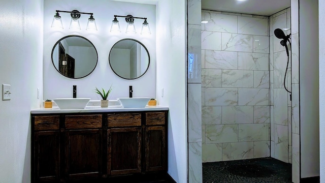 bathroom with tiled shower and vanity