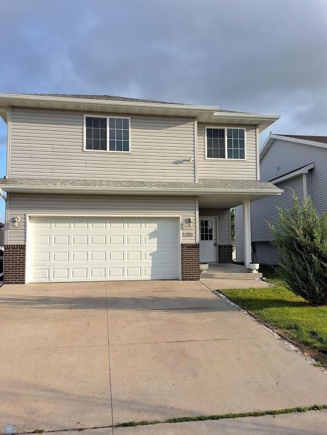 915 30th Ave W, West Fargo, ND 58078 - view of front facade featuring brick siding, an attached garage, and concrete driveway