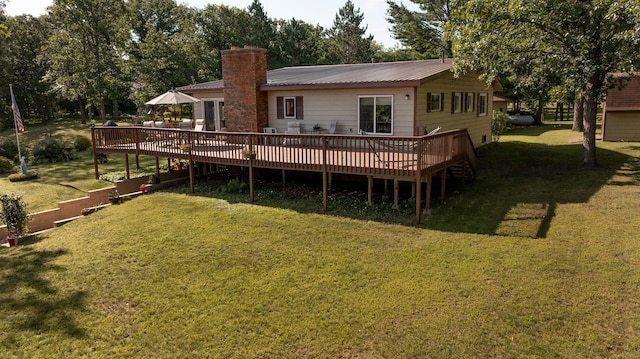 rear view of house featuring a wooden deck and a lawn