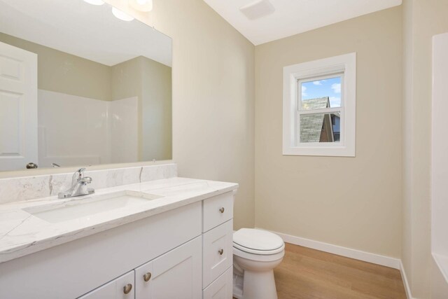 bathroom featuring vanity, a shower, hardwood / wood-style flooring, and toilet