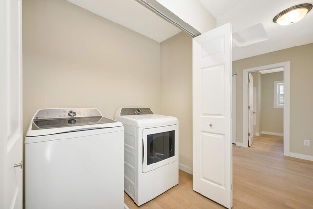 washroom featuring washer and clothes dryer and light hardwood / wood-style flooring