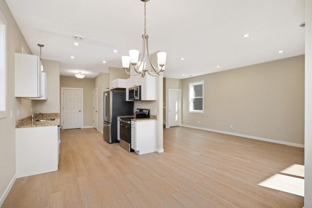 kitchen featuring stainless steel appliances, decorative light fixtures, light wood-type flooring, and white cabinets