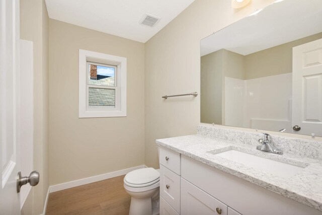 bathroom featuring vanity, toilet, and hardwood / wood-style floors