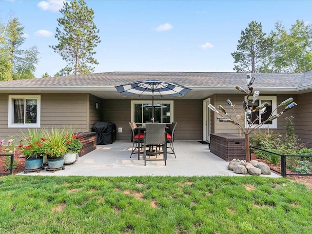 back of house with a patio area and a yard