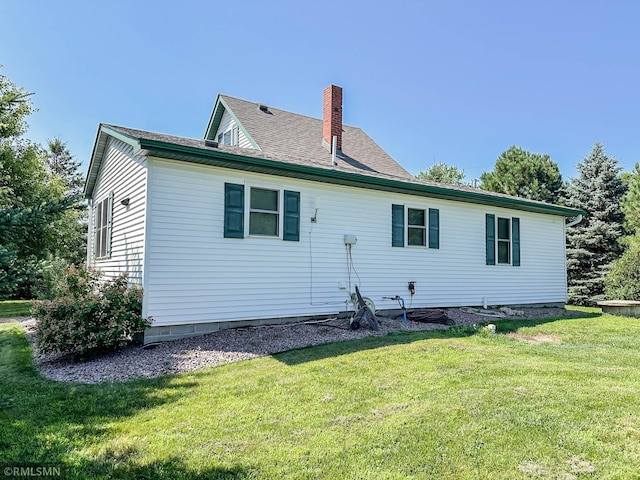 rear view of house featuring a lawn