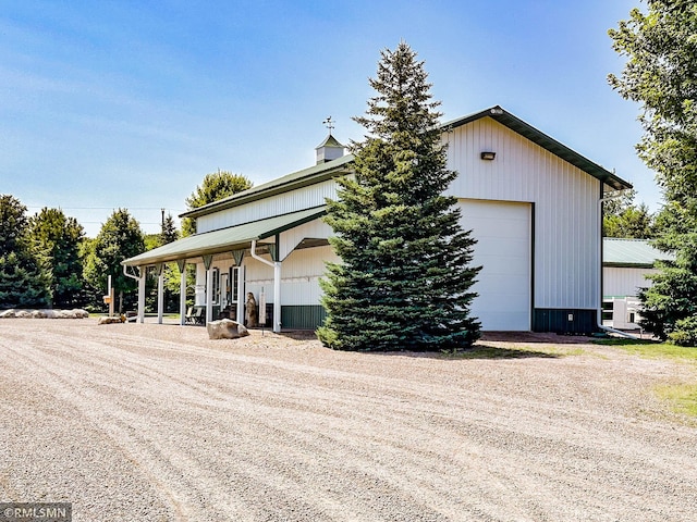 view of home's exterior with a garage and an outbuilding