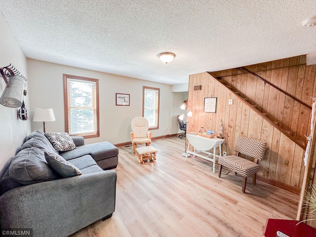 living room with a textured ceiling, wooden walls, and wood-type flooring