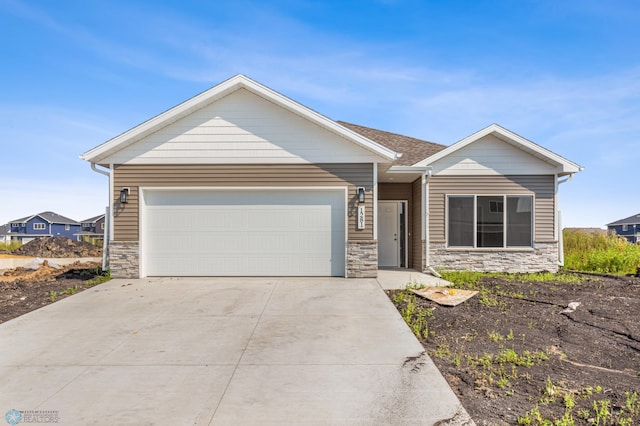 view of front of home featuring a garage, stone siding, and driveway