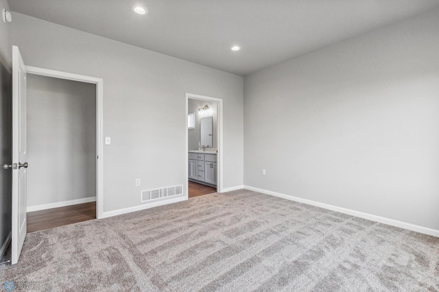 unfurnished bedroom with carpet, recessed lighting, visible vents, ensuite bath, and baseboards