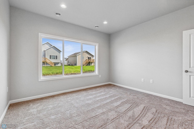 empty room featuring carpet, baseboards, and recessed lighting